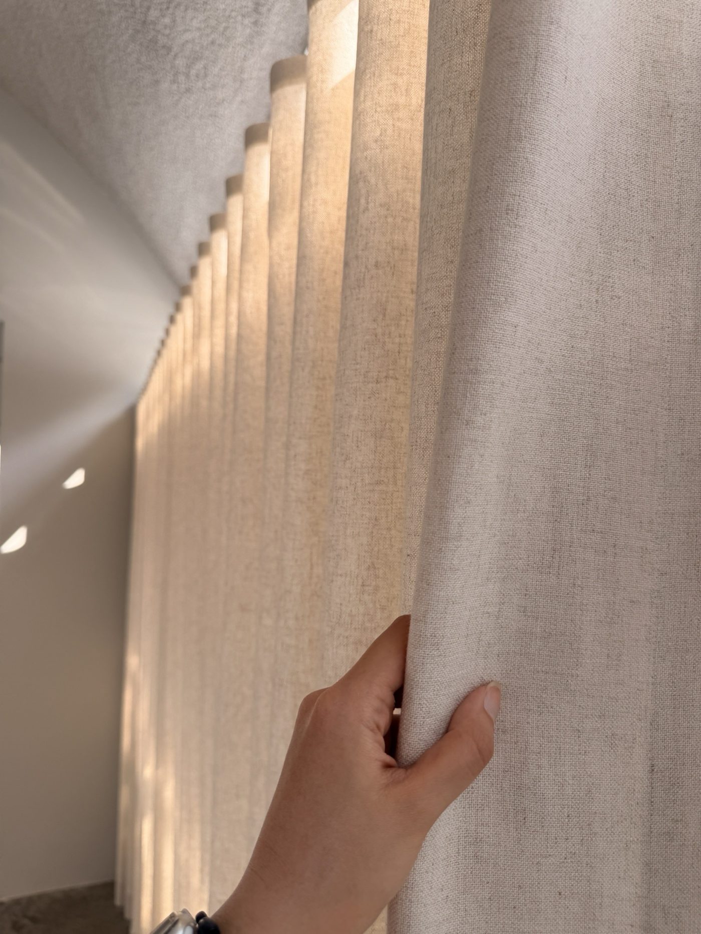 Linen and cotton held in natural light — a real installation photographed on a phone
